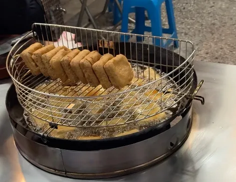 方記臭豆腐現點現炸,油鍋上的鐵網排著一列剛炸好、金黃酥脆的臭豆腐