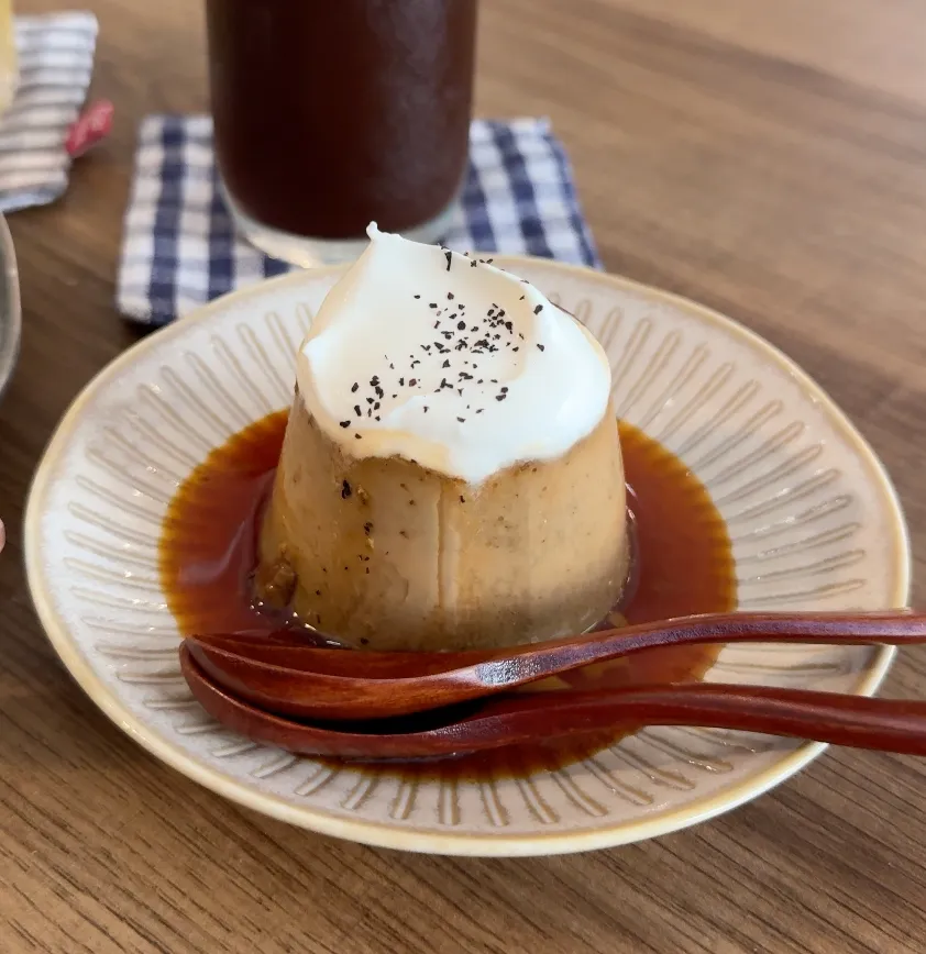 日知常屋的手工布丁,頂端擠上鮮奶油、淋上焦糖醬,搭配木湯匙