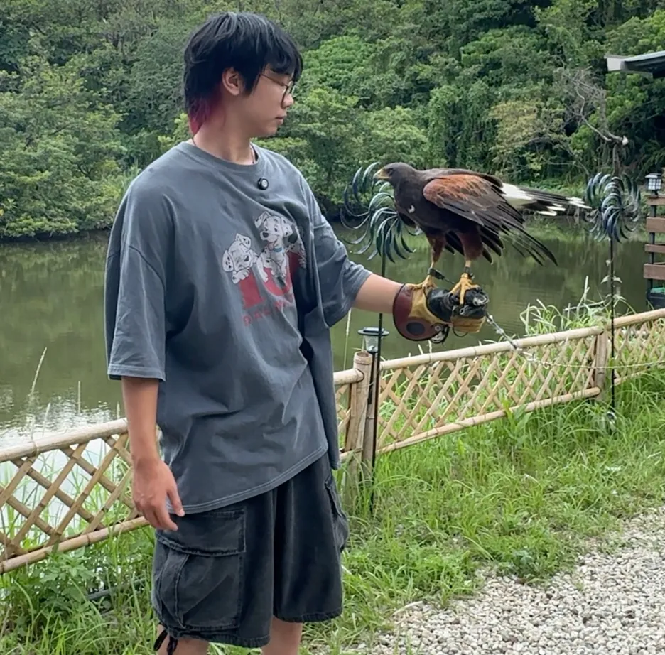 在陶淬湖庭園咖啡近距離接觸猛禽,戴上皮手套讓老鷹停在手臂上,背後就是園區的小湖泊