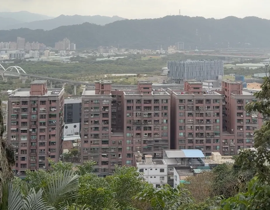 從鶯歌石觀景點俯瞰鶯歌市區,看得到成排住宅大樓、三鶯線高架橋與遠方山脈